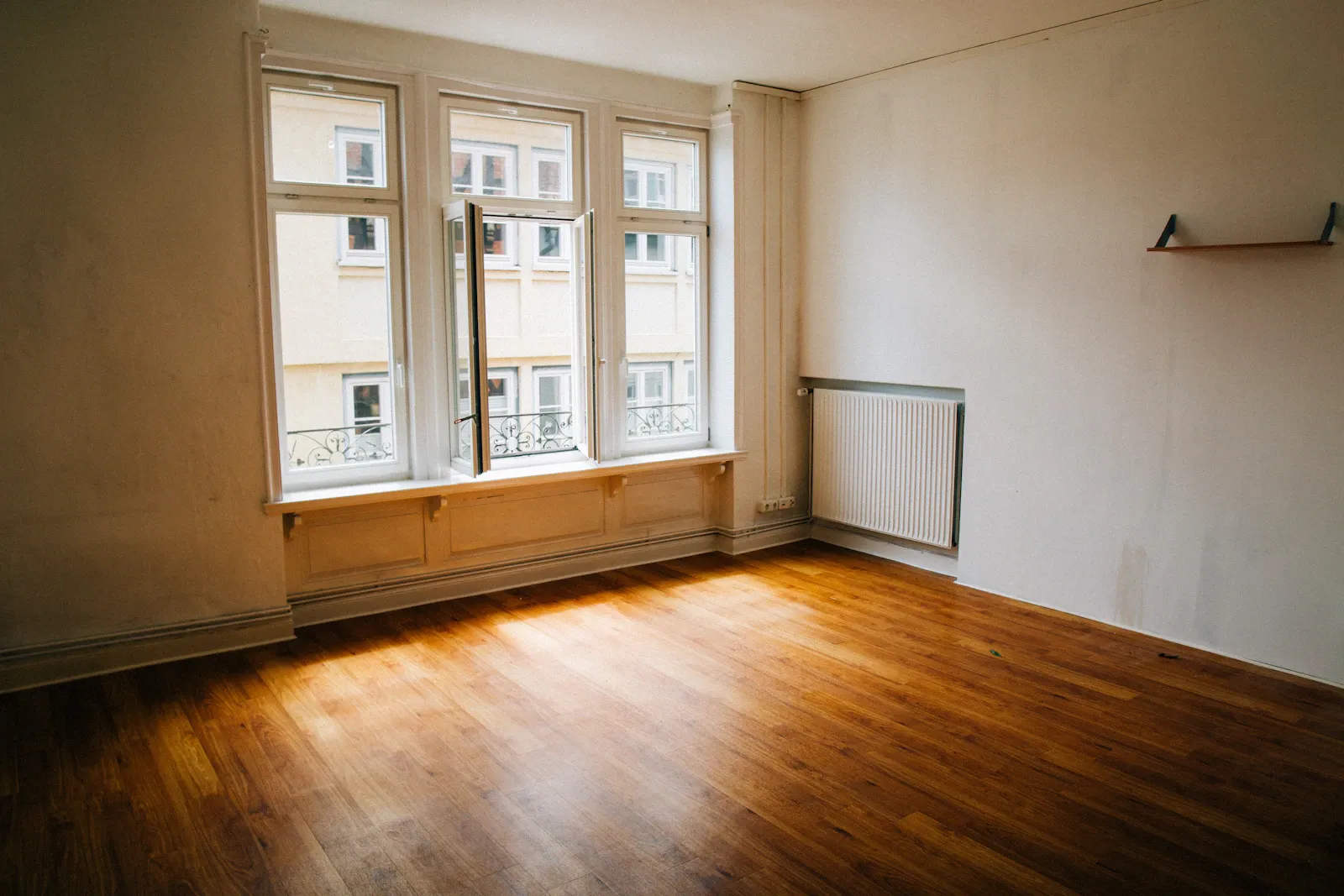 Immobilien vermieten — JL Immobilienservice Heilbronn Leeres helles Altbauzimmer mit Holzdielen und großen Fenstern.